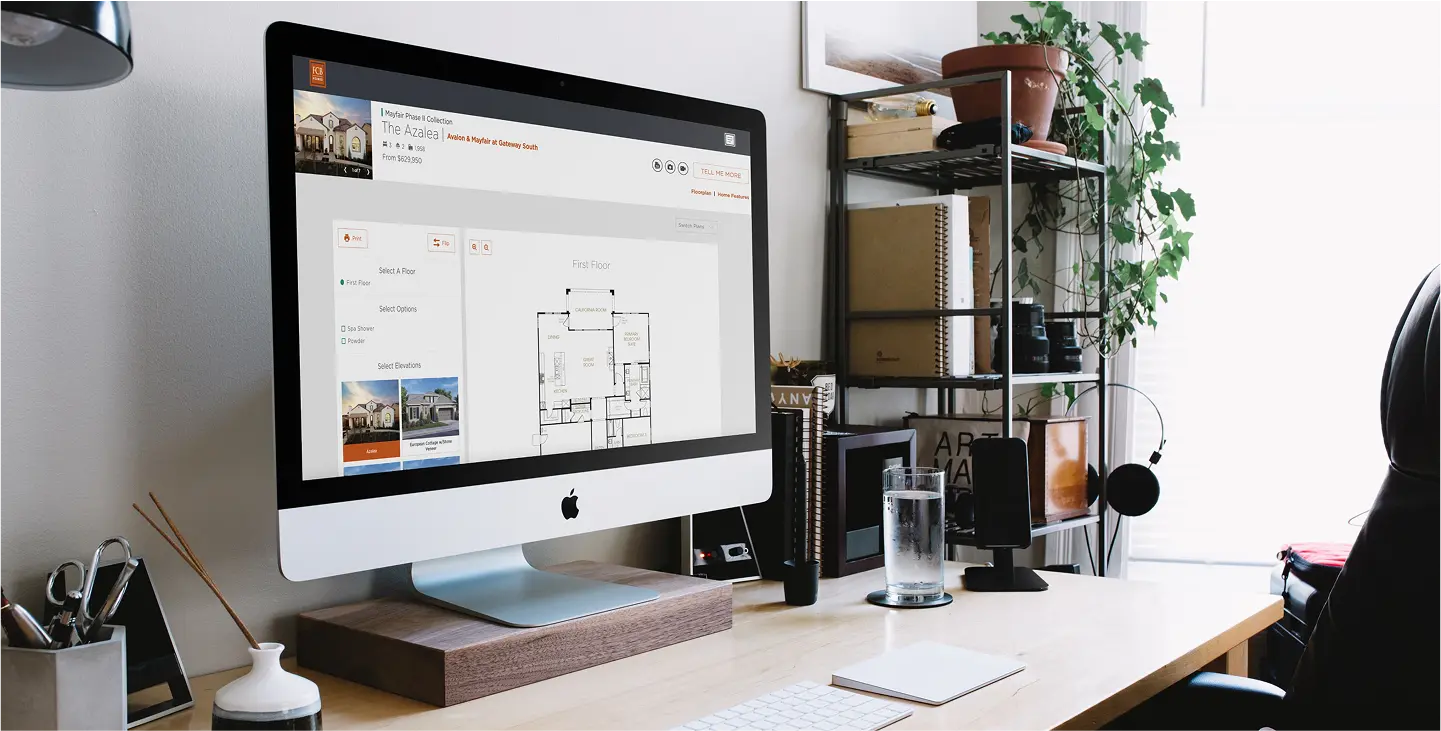 Computer desk displaying an iMac apple computer with FCB Homes displayed on the monitor